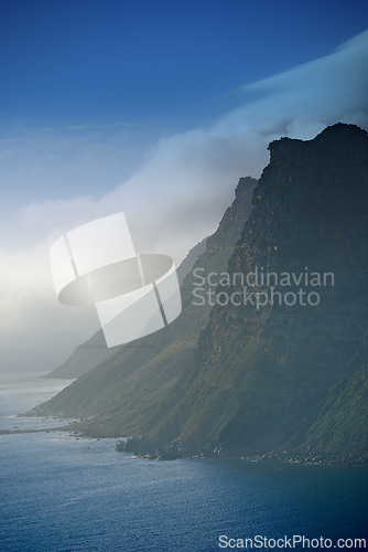 Image of Mountain, clouds and natural island with ocean, blue sky and calm landscape for travel location. Nature, fog and sustainable environment with earth, sea and holiday destination with tropical summer