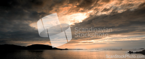 Image of Sunset, ocean and landscape of beach in Norway for holiday, vacation and travel destination. Nature, mountains and seashore, waves and water in evening for location, natural background and horizon