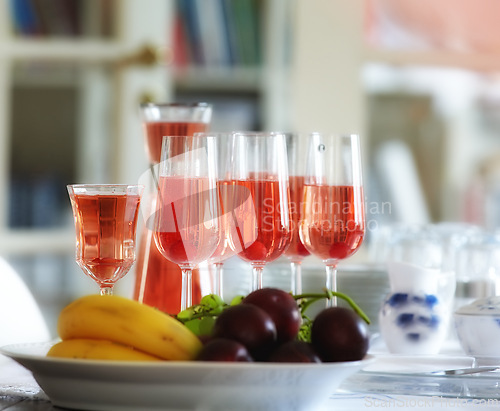 Image of Red, wine and fruit bowl in home, table with alcohol drink and glasses for guests. Hostess and preparation for celebration, events and holiday culture for relax with sangria for cocktail party