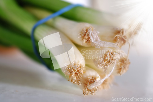 Image of Vegetable, closeup and spring onions for cooking, food and nutrition at home, house and kitchen with macro on table. Leeks, edible plants and fresh produce for vegan dish, clean eating and diet