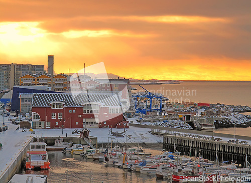 Image of Town, harbor and sunset on sea with buildings, boats and ship on water in landscape. City, port and travel from ocean dock in Norway on ferry or yacht for holiday, vacation or adventure in summer