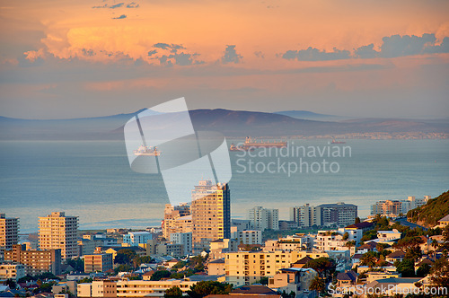 Image of City, building and ocean sunset with development infrastructure for summer holiday, explore or downtown. Water, urban and sea or mountain in South Africa or calm nature or evening, vacation or trip