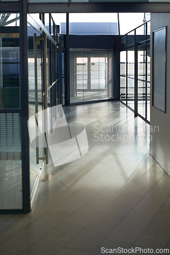 Image of Office, interior and hallway with glass windows in passage or corridor of modern workplace. Empty corporate building, structure or clean floor with walls of business architecture or industrial design