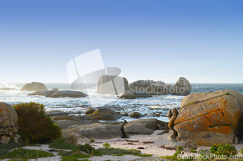 Image of Nature, landscape and rocks by ocean in South Africa for travel destination, holiday and vacation. Natural background, summer and waves, sea and boulders for scenic view, environment and location