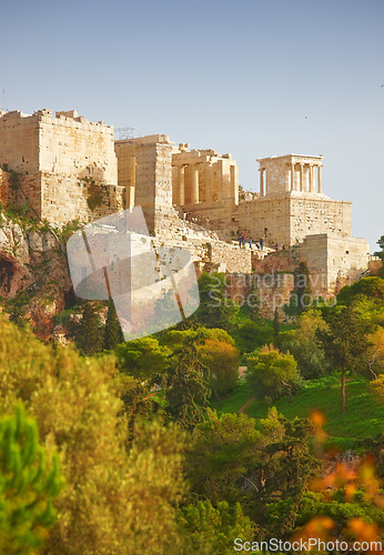 Image of Athens, Greece and building with trees in sunlight, ancient architecture of history site in summer. Marble, stone temple in greek culture with forest landscape, Europe and valley to travel location