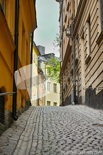 Image of Travel, stone and alley in vintage town with history, culture or holiday destination in Sweden. Vacation, old buildings and antique street in Stockholm with cobble road architecture in ancient city.