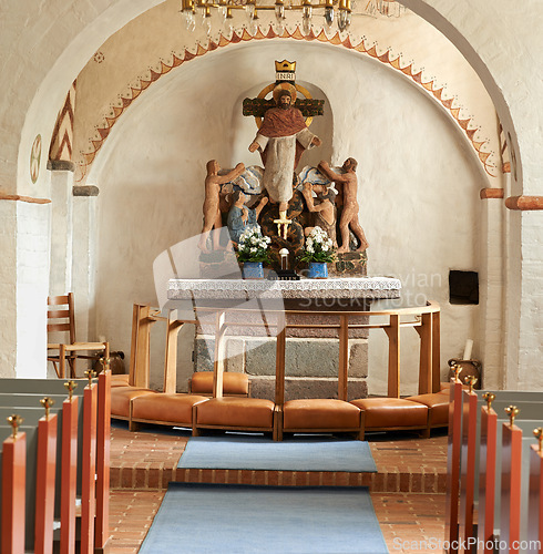 Image of Christian, shrine and sculpture in church for religion, worship and spiritual space for Catholic ceremony or culture. Praise, god and art of Jesus in cathedral chapel with kneelers in aisle to pray