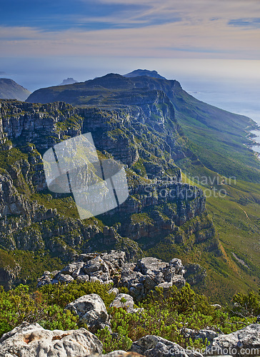 Image of Mountain, clouds and natural cliff with island, sunset sky and calm landscape for travel location. Nature, ocean and sustainable environment with earth, sea and tropical holiday destination in Hawaii