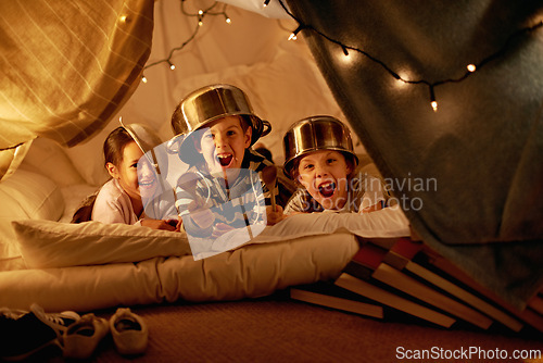 Image of Tent, lights and portrait of children at night in bedroom for playing, fun and bonding at home. Friends, youth and happy kids with spoon, helmet pots and blanket fort for games, relax and childhood