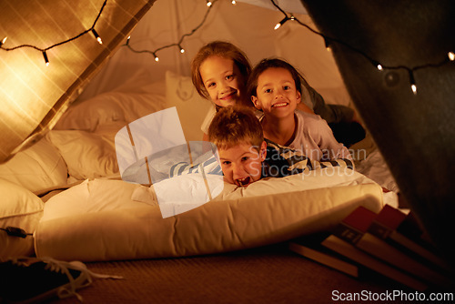 Image of Children, happy and playing in blanket fort with portrait for fantasy, bonding and string lights at night. Friends, kids and face with smile for pajama party, sleepover and pillow tent with lighting