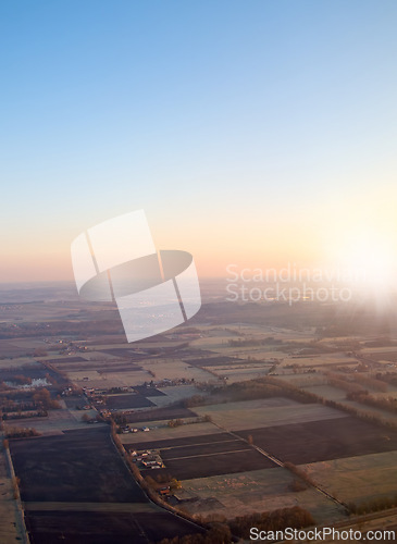 Image of Town, aerial view and countryside in outdoors at sunset, field and sustainable environment on travel. Blue sky, peace and mockup space in nature, drone and town for ecosystem at dusk or landscape