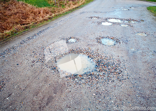 Image of Water, gravel and road in countryside with pothole with maintenance, infrastructure and farm transport in winter. Dirt, path and rain puddle in hole on rural street with damage, ground and nature.