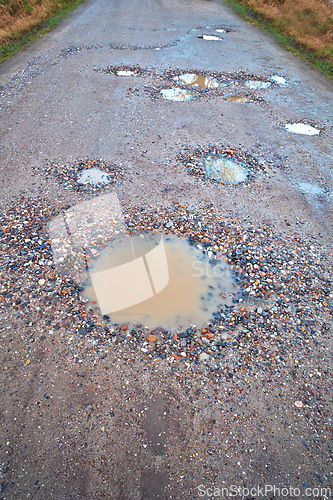 Image of Water, gravel and rural road with pothole with maintenance, infrastructure and farm transport in winter. Dirt, path and rain puddle in hole on countryside street with damage, ground and nature.