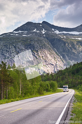 Image of Mountain, road trip and truck in forest with travel, holiday and countryside scenery in Norway. Nature, clouds in sky and asphalt for journey, vacation or outdoor adventure with snow, trees and woods