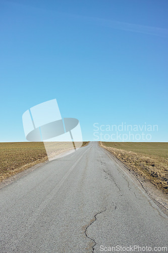 Image of Blue sky, road trip and desert landscape for travel, holiday and natural scenery in countryside. Nature, horizon and street for journey, vacation or outdoor adventure with peace, relax and wilderness