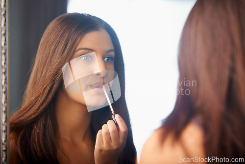 Image of Woman, lip gloss and application in mirror for makeup, glow and getting ready in bedroom with reflection. Shine, lips and person with cosmetics for self care, routine and beauty product in home