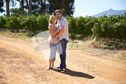 Image of Couple, portrait or hug outdoor in countryside, wine farm or vineyard for love, care or holiday. People, husband and wife embrace together at winery, nature or environment with vines, plants or trees