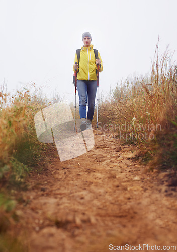 Image of Woman, hiking and fitness in nature with stick for journey, outdoor adventure and wellness in winter background. Travel, low angle and person in trekking pole for explore, mobility or balance.