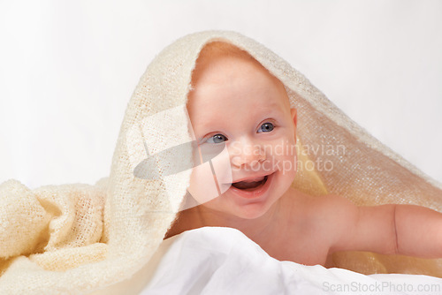 Image of Baby, smile or towel to play, relax or laugh in nursery at bath time in studio on white background. Happy, young child or blanket for peaceful rest for health, hygiene or childhood development