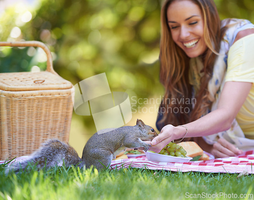 Image of Woman, squirrel and happy with picnic in nature to relax, grass and park for peace outdoors in environment. Female person, chipmunk and lawn with basket for food, smile and calm with animal.