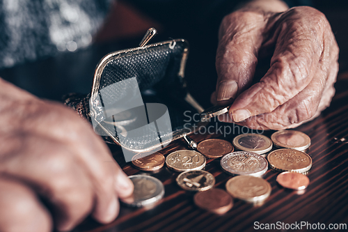 Image of Detailed closeup photo of elderly 96 years old womans hands counting remaining coins from pension in her wallet after paying bills. Unsustainability of social transfers and pension system.