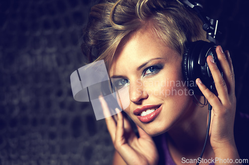 Image of Happy, portrait and woman with headphones for music, streaming and listening to radio in dark. Techno, sound and face of musician mixing track and relax with trippy audio for entertainment in home