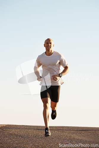 Image of Man, running in street and fitness outdoor, cardio and health, fresh air and training for marathon with sky background. Sport, exercise and athlete in city for workout with wellness and endurance