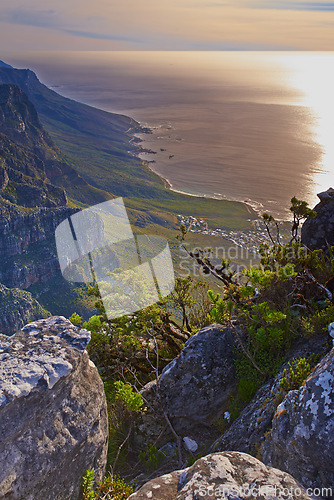 Image of Mountain, peak and landscape at sunset with sea, plants and perspective of nature in South Africa. Hill, countryside and aerial view of valley environment with biodiversity at ocean from hiking trail