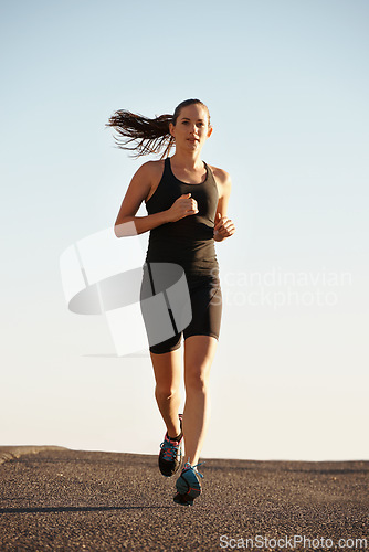 Image of Woman, running in street and fitness for cardio, health and fresh air when training for marathon with sky background. Sports, exercise and athlete in city for workout, wellness and endurance