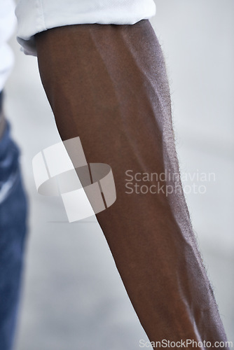 Image of Strong, arm and person with vein from muscle and shirt, fashion or closeup in white background. African, skincare and forearm of model with healthy fitness, wellness or muscular bodybuilder in office