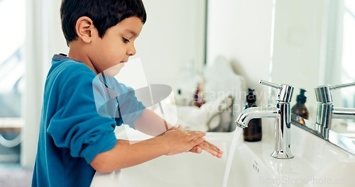 Image of Young boy, washing hands and hygiene for health, sustainability and water at routine at home. Male child, bathroom and clean with soap, foam and sink in healthy with hand washing and disinfection