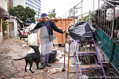 Image of Man, worker and cleaning of trash for waste management in junkyard with broom or playing with dog. Person, working or smile by dumpster site for scrap, recycling or garbage in neighborhood for litter