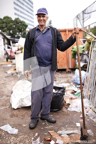 Image of Man, worker and cleaning of garbage for waste management in city with portrait, broom and happiness. Person, face and smile by dumpster site for scrap, recycling and trash in neighborhood for litter