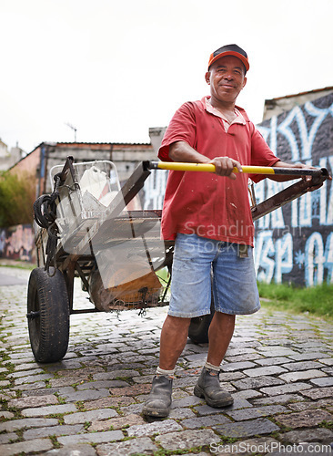 Image of Man, portrait and cart for trash in street for smile, walk and collect garbage for recycling for ecology. Person, rickshaw or barrow for sustainability, environment and favela on road in Sao Paulo