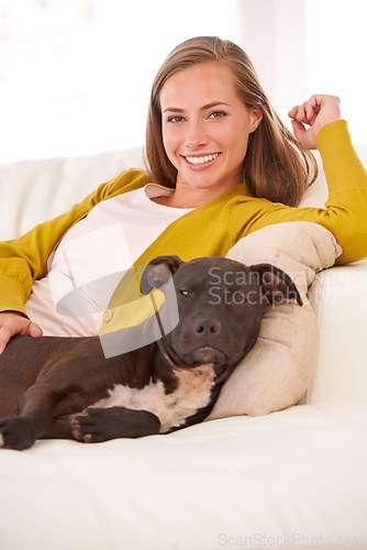 Image of Woman, dog and relax in living room in portrait, smile for pet love and bonding at home with domestic canine. Happy, positive and trust with foster or adoption, pitbull puppy and animal care on couch