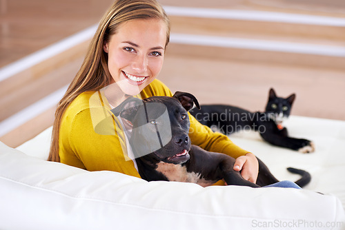 Image of Woman, pets and relax on sofa in portrait, smile for dog and cat love with bonding at home. Happy, positive and trust with foster or adoption, cuddle puppy in living room and domestic animal care