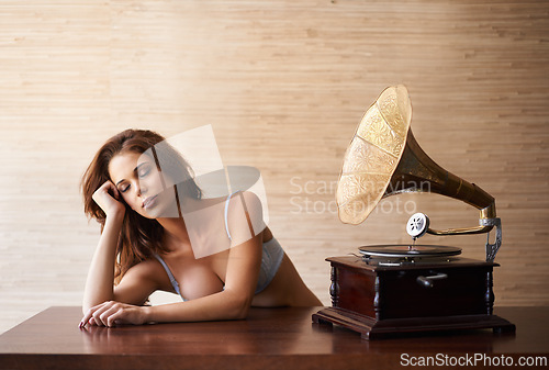 Image of Underwear, woman and music with bra, relax and gramophone on a table in a home with idea. Tired, morning and female person with phonograph and sound in a house with thinking and memory with song