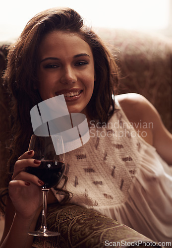 Image of Woman, portrait and armchair smile with wine to relax, home and alcohol in natural ambient light. Happy, enjoyment or liquid in glass, comfortable at house after meal in free time on weekend holiday