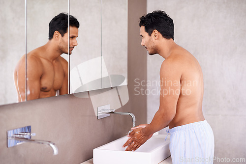 Image of Washing, skincare and mirror with man in bathroom for facial treatment, bacteria and hygiene. Healthy skin, dermatology and male person for grooming, wellness and morning routine in reflection.