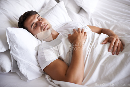 Image of Male person, sleep and bed for peace, wellness and happy for rest in white top and bedroom for home and happy. Man, relax and dreaming at house, calm and tired after day at work and taking nap