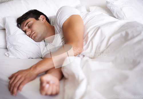 Image of Man, sleep and bed for peace, wellness and home for rest in pajamas and bedroom for relaxing and sleepwear. Male person, relax and dreaming at house, calm and tired after busy day and taking nap