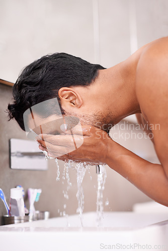 Image of Skincare, splash or man washing face in bathroom for self care, wellness or morning routine. Facial, cleaning or profile of male person at a basin for water, beauty or hydration, cosmetic or results
