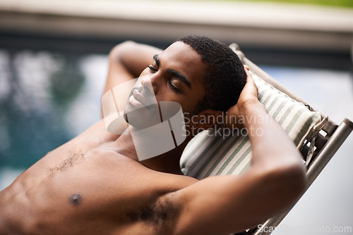 Image of Man, pool and relax on chair, peace and swimming on weekend for having fun on summer holiday. Black male person, rest and calm at resort on travel to Nigeria, vacation and outdoors for leisure
