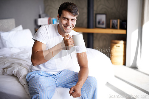 Image of Man, bedroom and morning coffee portrait and smile, weekend off in apartment to relax with attractive male person. Casual and holiday or home, Saturday off day and comfortable positive guy with cup