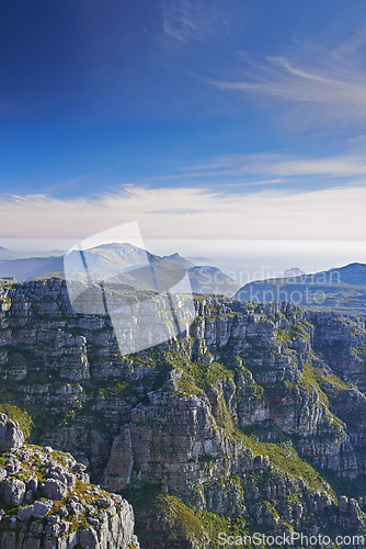 Image of Mountains, landscape and clouds in sky for travel, hiking or eco friendly tourism by ocean or sea on horizon. Aerial view of environment, nature and rock texture or mockup in Cape Town, South Africa