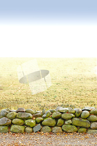 Image of Landscape, land and wall with stone for agriculture in nature with mockup space, grass and natural environment in Amsterdam. Field, meadow and farmland for farming, conservation or sky in countryside