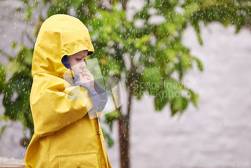 Image of Child, jacket and rain in outdoor for fashion, play and walk to kindergarten in cold. Boy, cute and adorable kid with clothes in water droplets in garden or backyard for childhood and innocent