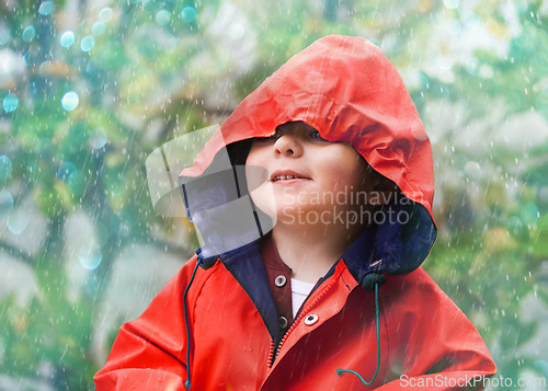 Image of Child, rain and raincoat in style for fashion, jacket or cold weather in winter. Little boy, male toddler and kid in drizzle by tree, bokeh or environment with windbreaker for chilly season in London