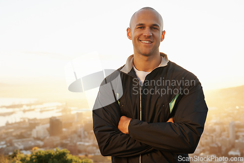 Image of Happy man, portrait and fitness professional with sunset on mountain for workout, exercise or outdoor raining. Male person or athlete with smile and arms crossed in confidence for health and wellness