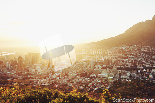 Image of Sun, top view of city with landscape and mountains, buildings and architecture with nature outdoor. Flare, natural light and urban development background for property, horizon or skyline with travel